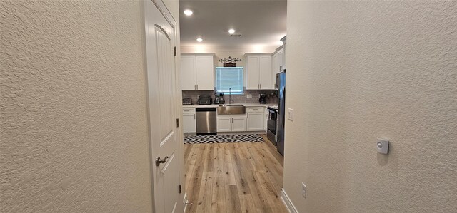 18103 Shaman Dr, Galveston, TX 77554 - hallway with a textured wall, light wood-style flooring, a sink, and recessed lighting