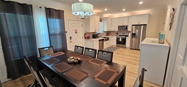 18103 Shaman Dr, Galveston, TX 77554 - dining space with light wood-style flooring, ornamental molding, and recessed lighting