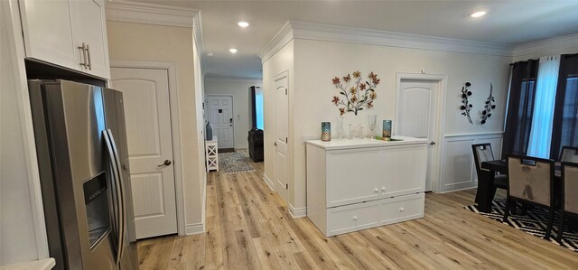 18103 Shaman Dr, Galveston, TX 77554 - kitchen with stainless steel refrigerator with ice dispenser, light wood-style floors, ornamental molding, white cabinetry, and recessed lighting