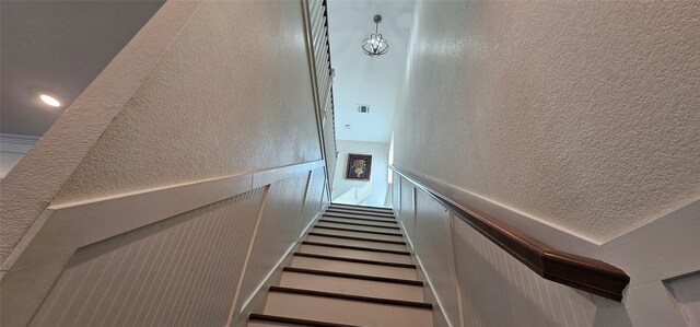 18103 Shaman Dr, Galveston, TX 77554 - staircase with a textured wall and wainscoting