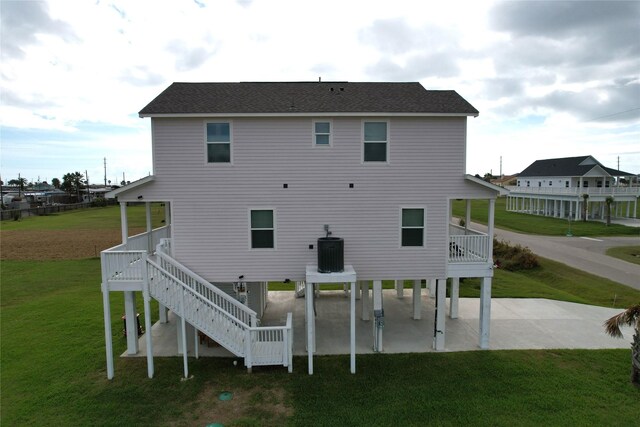 18103 Shaman Dr, Galveston, TX 77554 - back of property featuring a patio area, stairway, central air condition unit, a lawn, and a wooden deck