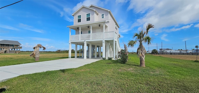 raised beach house with a porch, a carport, and a front lawn