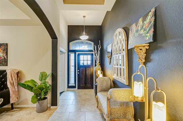 tiled foyer with a towering ceiling