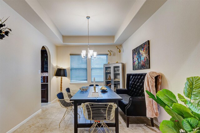 3614 Daintree Park Dr, Katy, TX 77494 - dining area featuring a raised ceiling, arched walkways, a chandelier, and baseboards