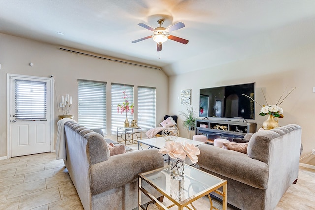 tiled living room with a wealth of natural light, lofted ceiling, and ceiling fan