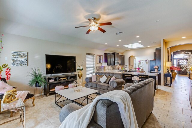 3614 Daintree Park Dr, Katy, TX 77494 - living room with arched walkways, ceiling fan, a skylight, light tile patterned flooring, and recessed lighting