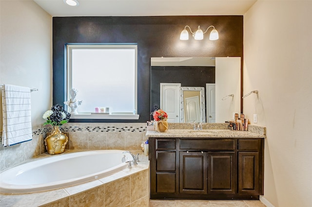 bathroom with vanity and tiled tub