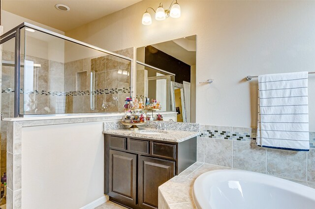 bathroom with vanity and separate shower and tub