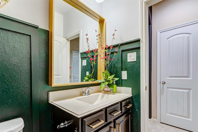 bathroom with tile patterned flooring, vanity, and toilet