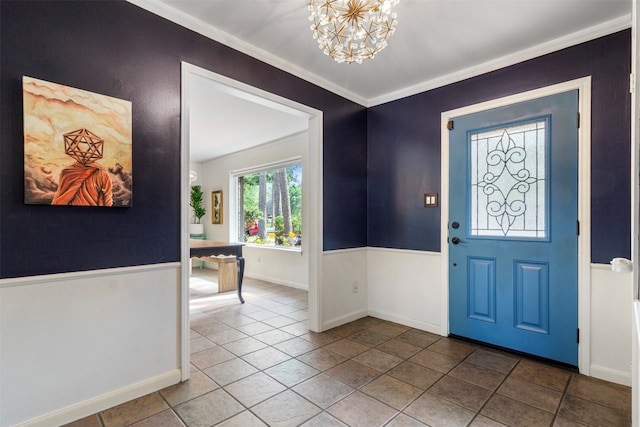 entryway featuring tile patterned floors, crown molding, and a notable chandelier