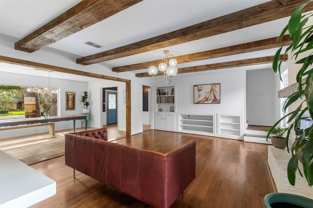 living room featuring beam ceiling, dark hardwood / wood-style flooring, and a chandelier