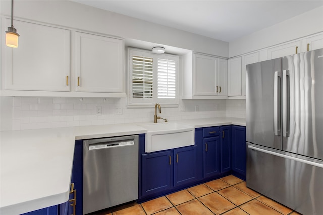 kitchen with decorative backsplash, stainless steel appliances, blue cabinetry, pendant lighting, and white cabinetry