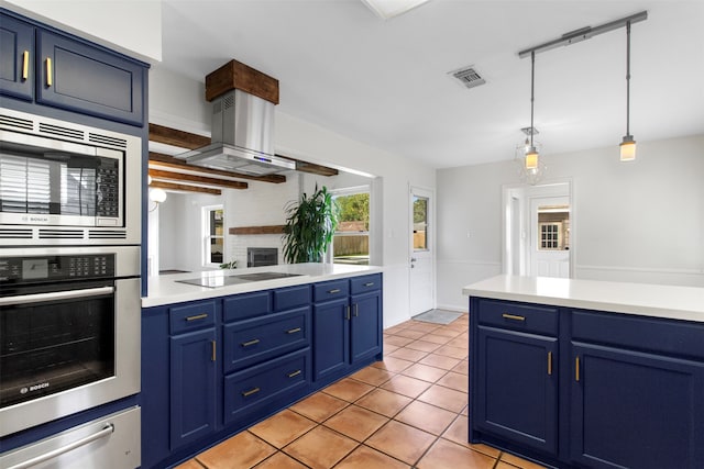 kitchen featuring island exhaust hood, stainless steel appliances, blue cabinets, hanging light fixtures, and light tile patterned flooring