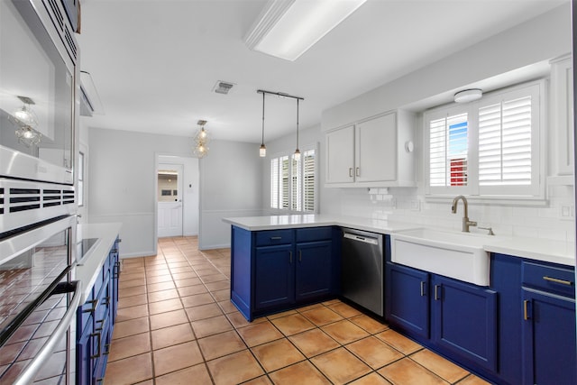 kitchen featuring white cabinets, blue cabinets, hanging light fixtures, stainless steel dishwasher, and kitchen peninsula