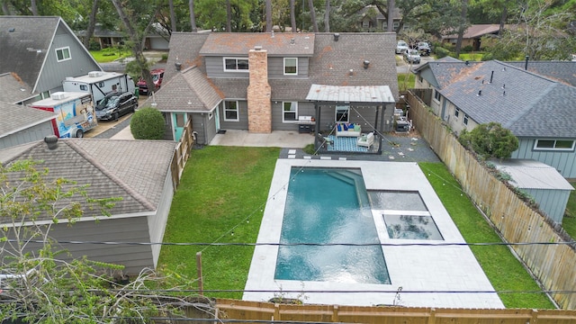 back of house featuring a fenced in pool, a patio area, and a yard