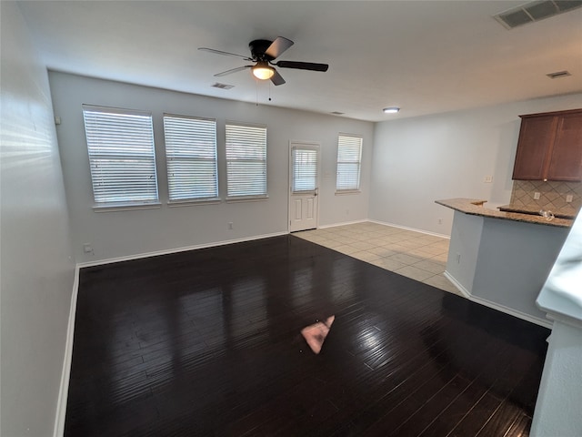 unfurnished living room featuring ceiling fan and light hardwood / wood-style flooring