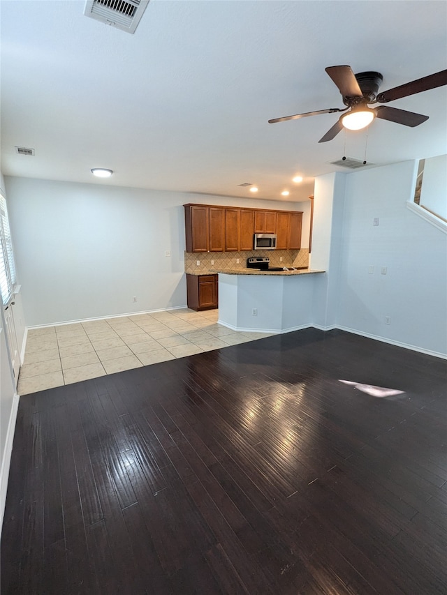 unfurnished living room featuring light wood-type flooring and ceiling fan