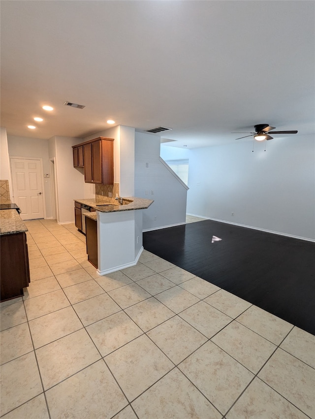 kitchen with ceiling fan, light tile patterned floors, decorative backsplash, and kitchen peninsula