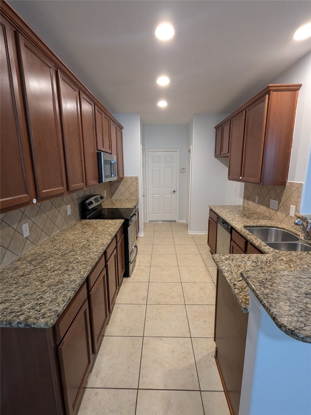 kitchen featuring backsplash, appliances with stainless steel finishes, and sink