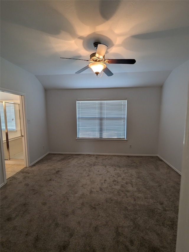 carpeted spare room featuring ceiling fan and vaulted ceiling