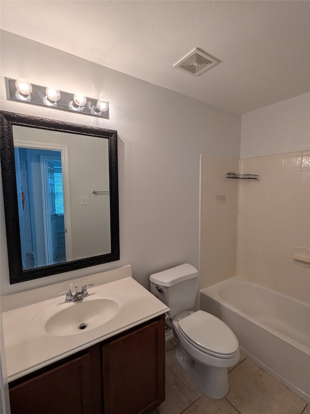 full bathroom featuring vanity, a textured ceiling, tile patterned flooring, toilet, and tiled shower / bath