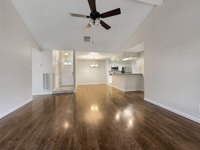 unfurnished living room with ceiling fan with notable chandelier, high vaulted ceiling, dark hardwood / wood-style floors, and a textured ceiling