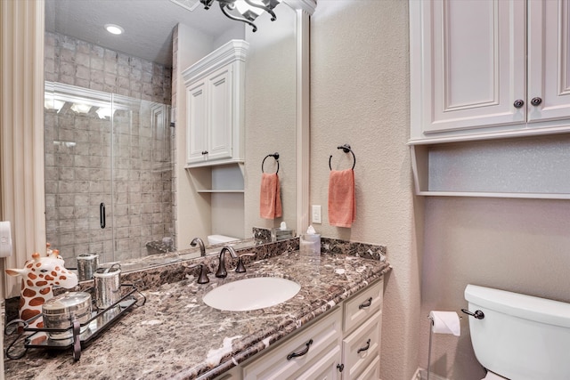 bathroom featuring an enclosed shower, vanity, and toilet