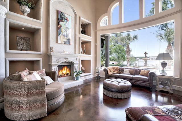 living room featuring a towering ceiling and built in shelves