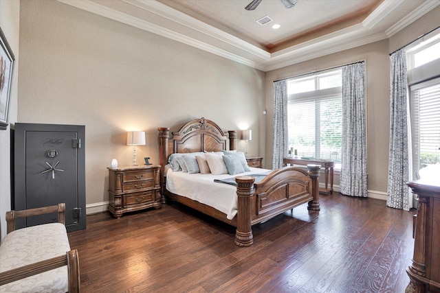 bedroom with ceiling fan, dark hardwood / wood-style floors, ornamental molding, and a tray ceiling