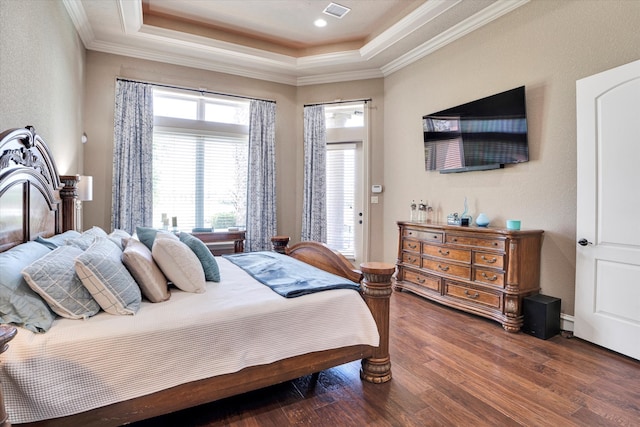 bedroom with dark wood-type flooring, a raised ceiling, and crown molding