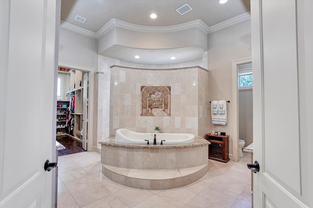 bathroom with toilet, crown molding, and tiled tub