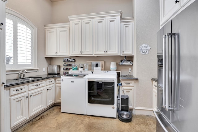 washroom with cabinets, light tile patterned floors, sink, and independent washer and dryer