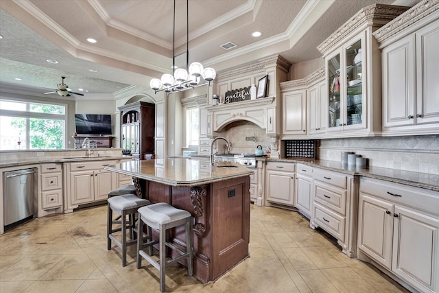 kitchen with ornamental molding, a breakfast bar area, dishwasher, and a tray ceiling