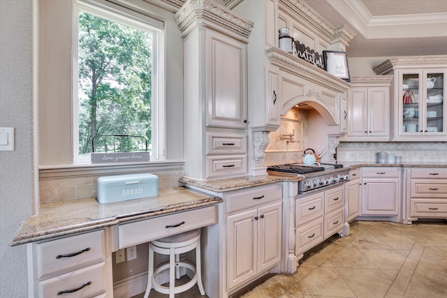 kitchen with tasteful backsplash, a healthy amount of sunlight, ornamental molding, and stainless steel gas stovetop