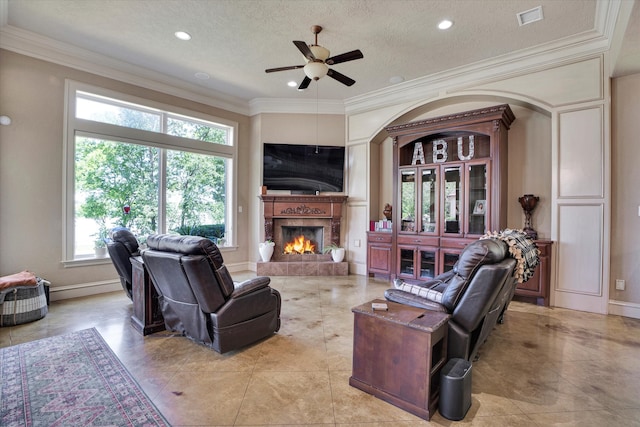 living room featuring a wealth of natural light, a textured ceiling, and crown molding