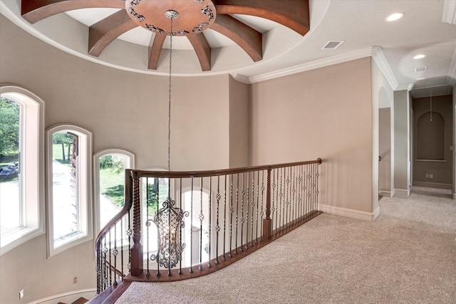 hall with ornamental molding, plenty of natural light, and carpet floors