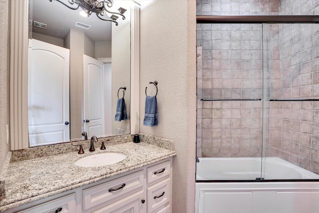 bathroom with vanity and combined bath / shower with glass door