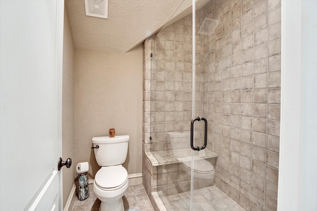 bathroom featuring a shower with door, a textured ceiling, toilet, and tile patterned flooring