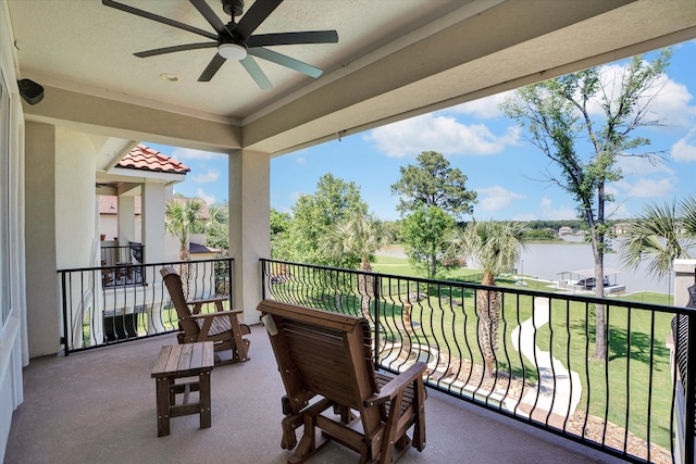 balcony featuring a water view and ceiling fan