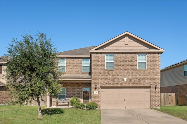 traditional-style home with brick siding, a front yard, fence, a garage, and driveway