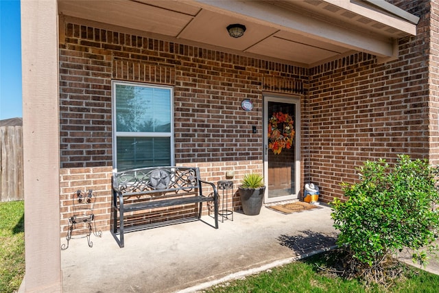 view of exterior entry featuring brick siding