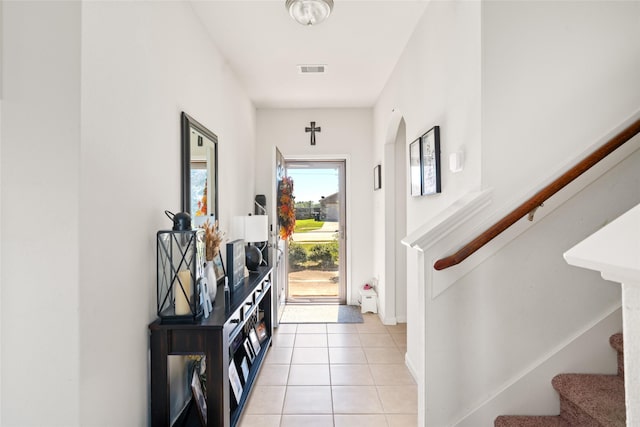 doorway featuring stairs, light tile patterned floors, and visible vents