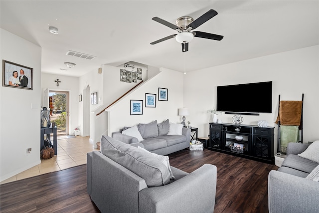 living room featuring visible vents, ceiling fan, wood finished floors, baseboards, and stairs