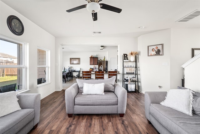 living room featuring ceiling fan, dark wood finished floors, and visible vents