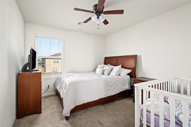 bedroom with light colored carpet, visible vents, and ceiling fan