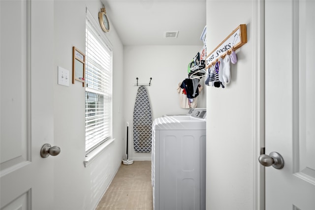 laundry area featuring laundry area, visible vents, washing machine and clothes dryer, and light tile patterned floors