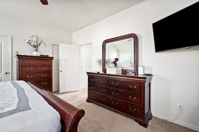 bedroom with a ceiling fan, light carpet, and baseboards