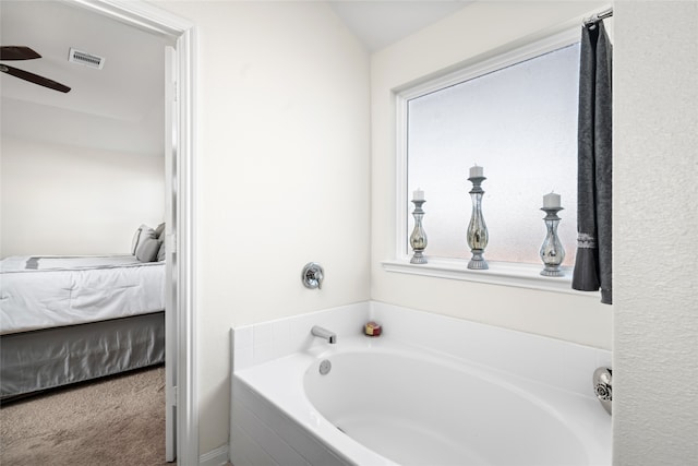 ensuite bathroom featuring a bath, ceiling fan, ensuite bath, and visible vents