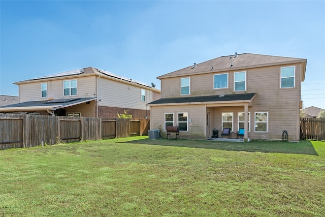 back of property with a fenced backyard, central AC unit, and a yard