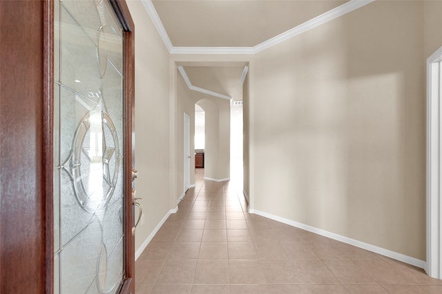 corridor featuring light tile patterned floors, ornamental molding, and plenty of natural light